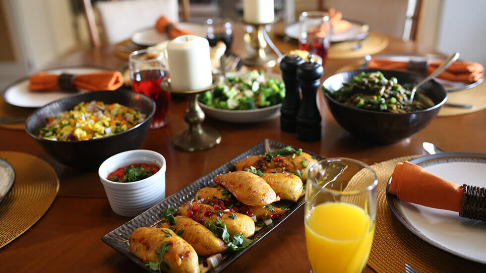 Dinner table set with chicken breasts and various other side plates