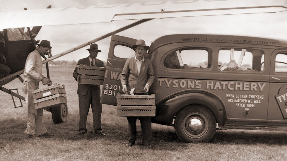 Tyson hatchery vehicle with three men carrying chicken containers